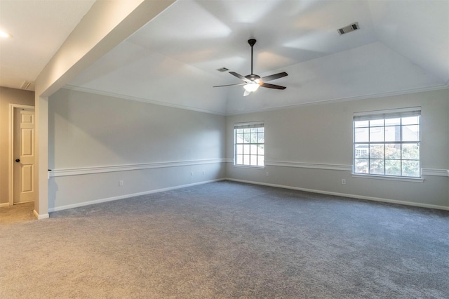 carpeted spare room featuring lofted ceiling, crown molding, a raised ceiling, and ceiling fan