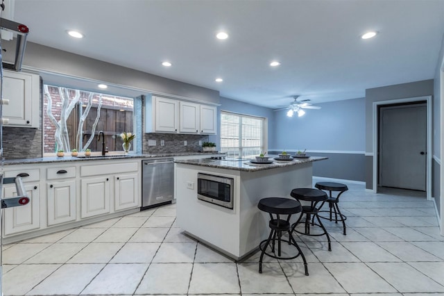 kitchen with white cabinetry, sink, stainless steel appliances, and a kitchen island