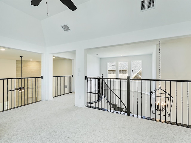 hallway with lofted ceiling, carpet floors, and a notable chandelier