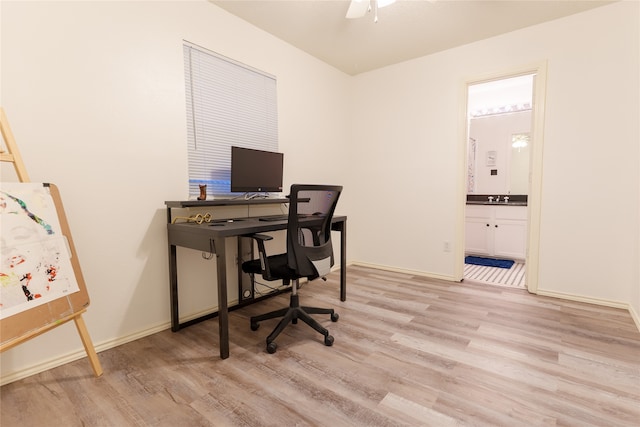 office area featuring ceiling fan, sink, and light wood-type flooring