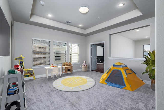 rec room with a tray ceiling and carpet floors