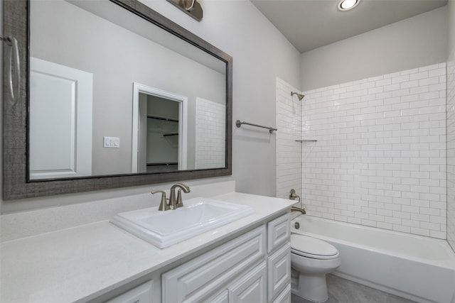 full bathroom featuring tiled shower / bath, vanity, and toilet