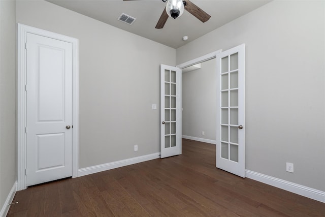 spare room featuring french doors, ceiling fan, and dark hardwood / wood-style flooring