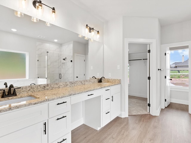 bathroom featuring vanity, wood-type flooring, and walk in shower