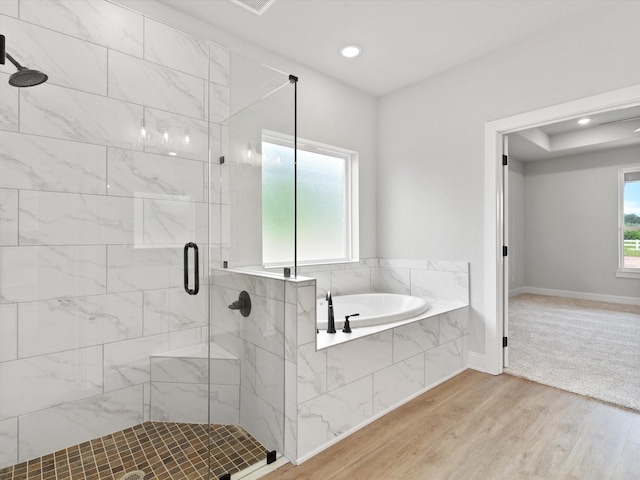 bathroom featuring hardwood / wood-style flooring and shower with separate bathtub