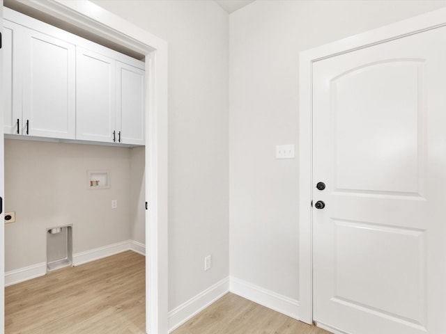 washroom with washer hookup, electric dryer hookup, light hardwood / wood-style floors, and cabinets