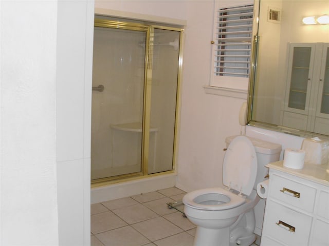 bathroom with vanity, toilet, tile patterned floors, and walk in shower