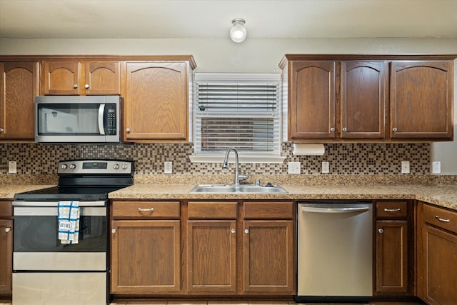 kitchen with decorative backsplash, sink, and stainless steel appliances