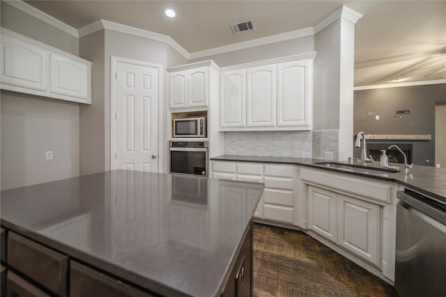 kitchen featuring tasteful backsplash, stainless steel appliances, crown molding, sink, and white cabinets