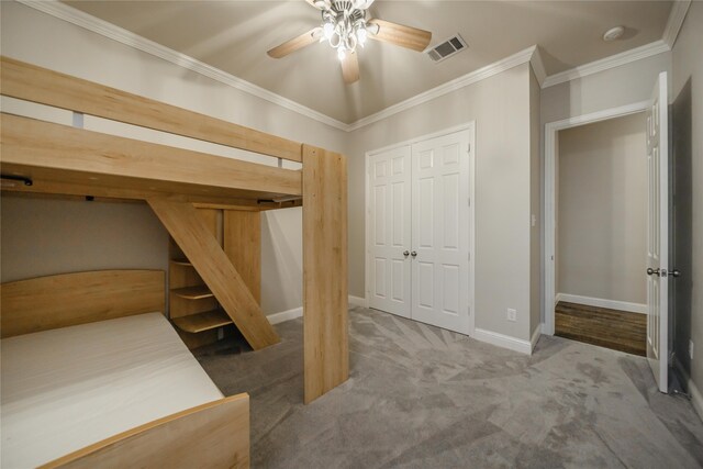 carpeted bedroom featuring a closet, ceiling fan, and ornamental molding