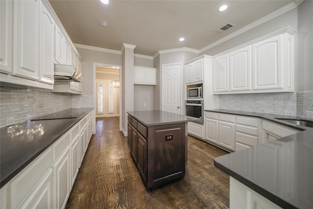 kitchen with dark wood-type flooring, white cabinets, stainless steel appliances, and sink