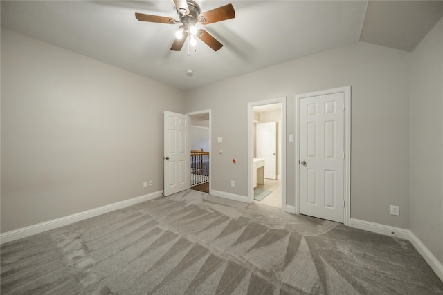 unfurnished bedroom with connected bathroom, ceiling fan, light carpet, and lofted ceiling