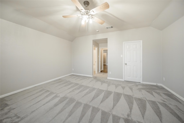 unfurnished bedroom featuring ceiling fan, a closet, light colored carpet, and vaulted ceiling