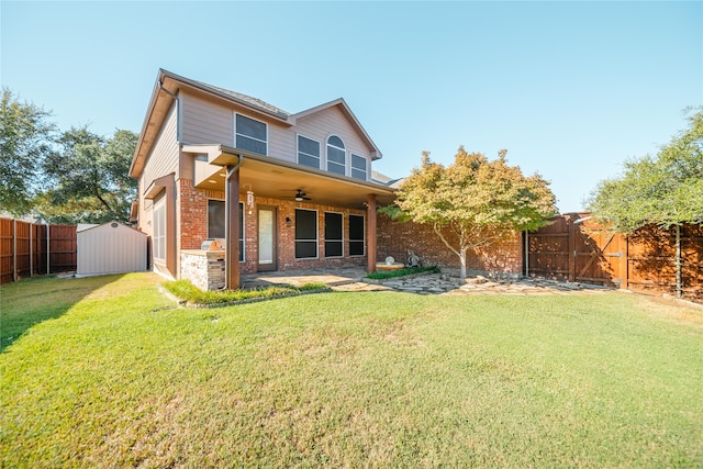 back of house featuring ceiling fan, a patio area, a yard, and a storage shed