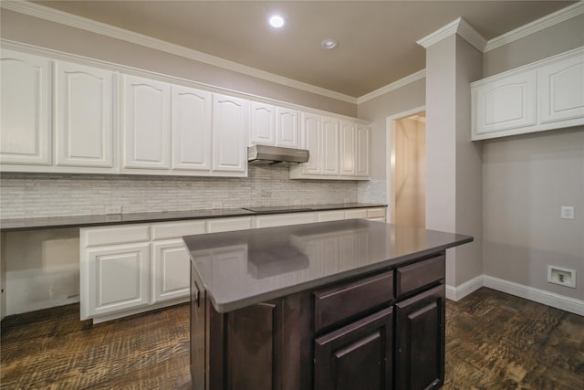 kitchen featuring a center island, white cabinets, ornamental molding, tasteful backsplash, and dark hardwood / wood-style flooring