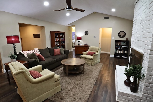 living room with ceiling fan, vaulted ceiling, dark hardwood / wood-style flooring, and a brick fireplace