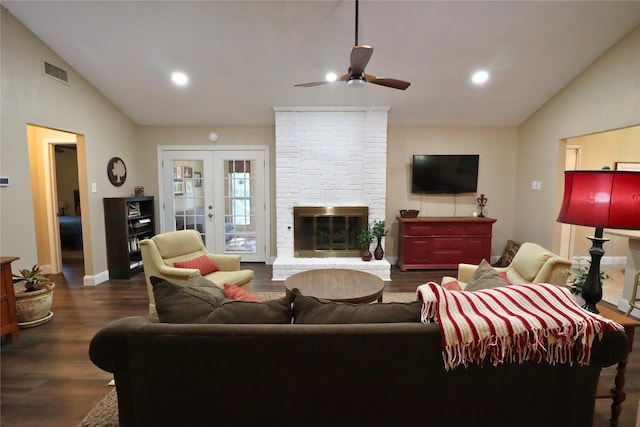 living room with ceiling fan, lofted ceiling, a fireplace, dark wood-type flooring, and french doors