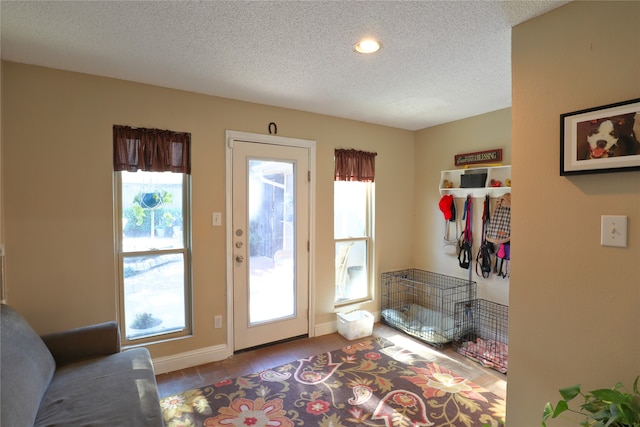 doorway to outside with light tile patterned flooring and a textured ceiling