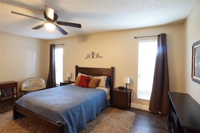 bedroom featuring a textured ceiling, ceiling fan, and dark hardwood / wood-style floors