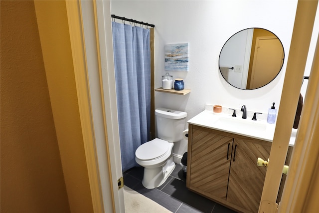 bathroom with toilet, vanity, and tile patterned floors