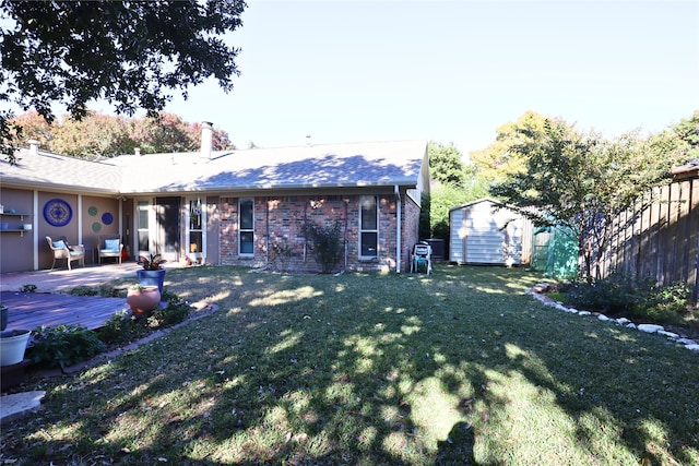 rear view of property featuring a lawn and a shed