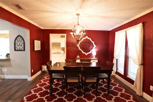 dining area with dark hardwood / wood-style flooring, crown molding, and a chandelier