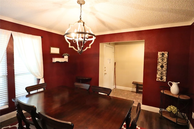 dining room featuring a textured ceiling, hardwood / wood-style floors, ornamental molding, and an inviting chandelier