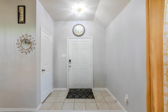 tiled entrance foyer with vaulted ceiling