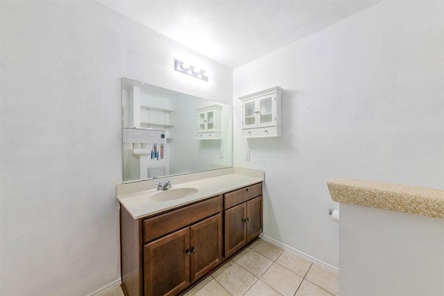 bathroom with toilet, vanity, and tile patterned floors