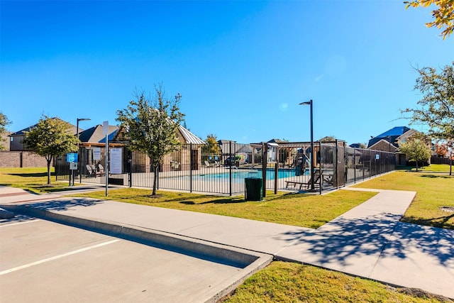 view of community with a lawn and a swimming pool