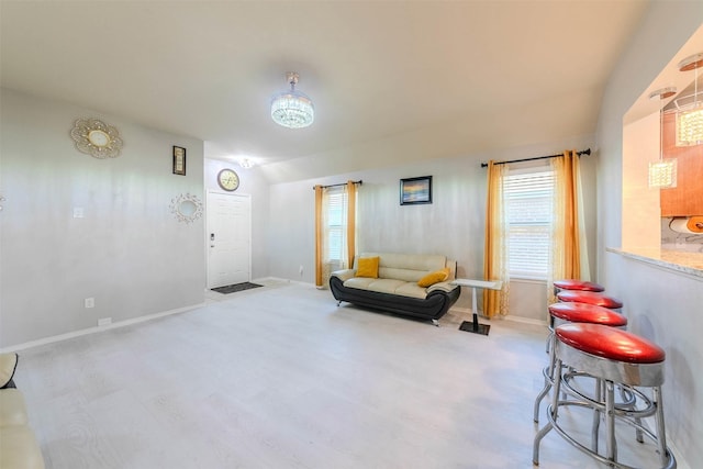 living area with vaulted ceiling and light hardwood / wood-style flooring