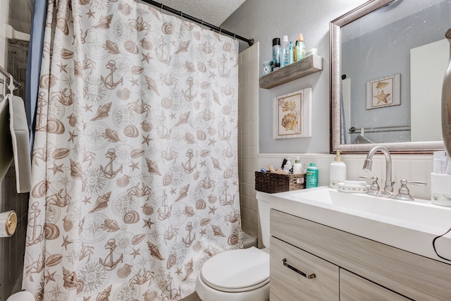 full bathroom with vanity, shower / bath combination with curtain, toilet, and a textured ceiling