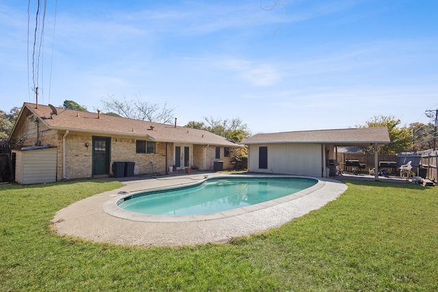 view of pool with central AC, a patio area, and a lawn