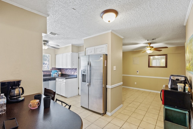 kitchen featuring white cabinets, decorative backsplash, ornamental molding, and stainless steel appliances