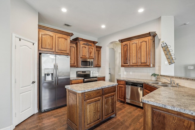 kitchen with brown cabinetry, visible vents, stainless steel appliances, and light countertops