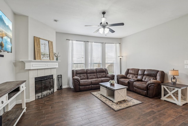 living room featuring a fireplace, baseboards, dark wood finished floors, and a ceiling fan