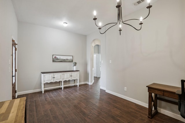 interior space with baseboards, visible vents, arched walkways, and dark wood finished floors