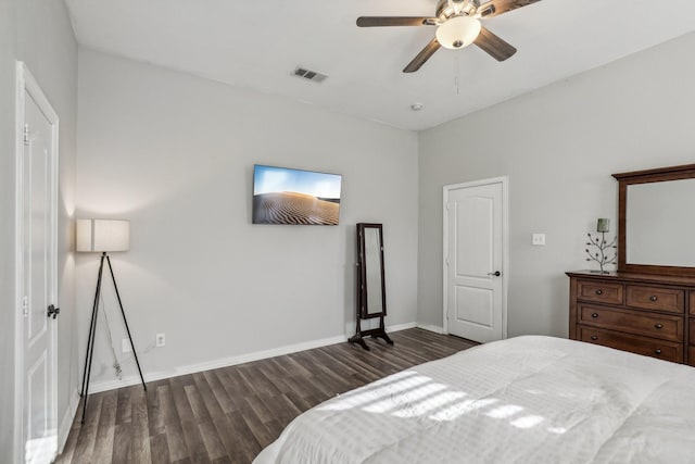 bedroom with dark wood-style floors, ceiling fan, visible vents, and baseboards