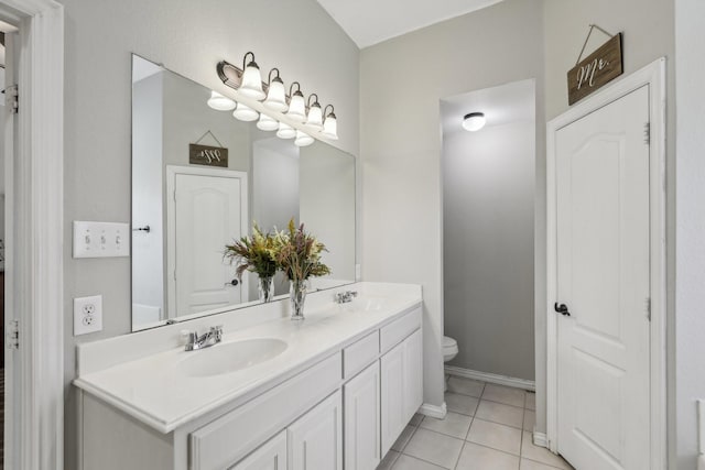 full bath with double vanity, tile patterned flooring, toilet, and a sink