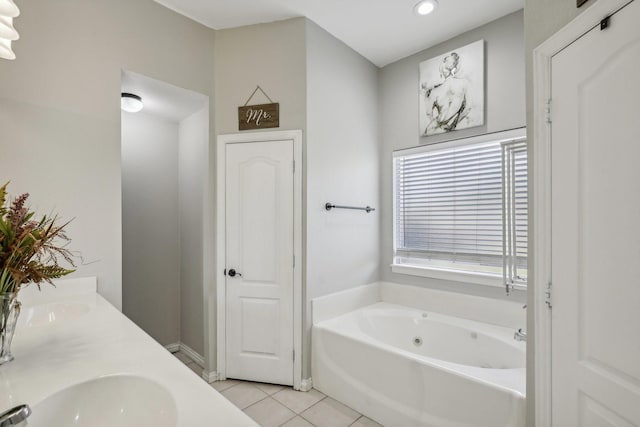 bathroom featuring tile patterned flooring, double vanity, a sink, and a bath