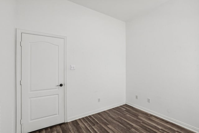 empty room featuring dark wood-style floors and baseboards