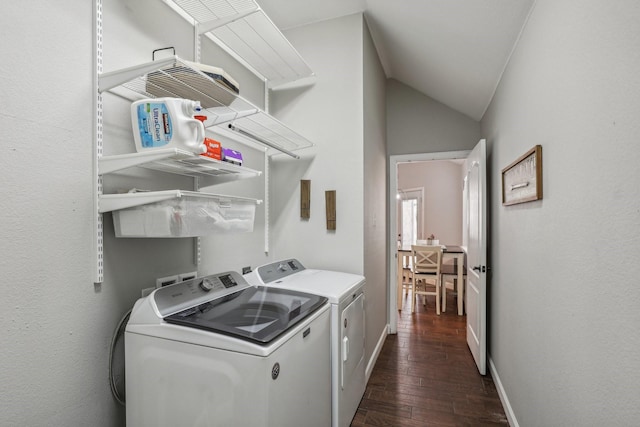 clothes washing area with dark wood-style floors, laundry area, washer and clothes dryer, and baseboards