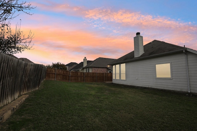 yard at dusk with a fenced backyard