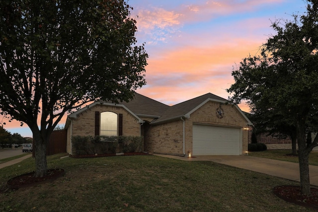 ranch-style home featuring concrete driveway, brick siding, a yard, and an attached garage