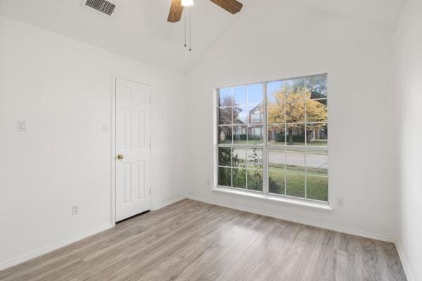 empty room with ceiling fan, high vaulted ceiling, and light wood-type flooring