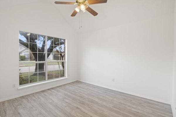 spare room featuring light hardwood / wood-style floors, high vaulted ceiling, and ceiling fan