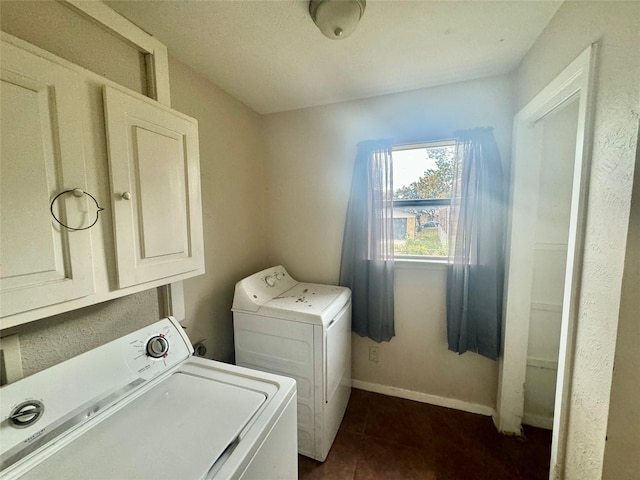 clothes washing area with cabinets and separate washer and dryer