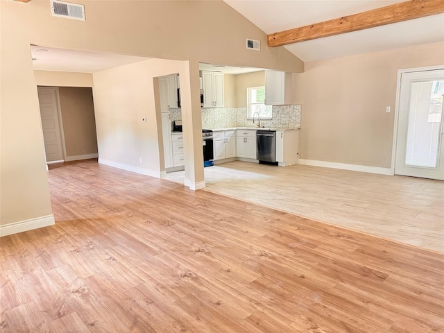 unfurnished living room featuring vaulted ceiling with beams, light hardwood / wood-style flooring, and sink