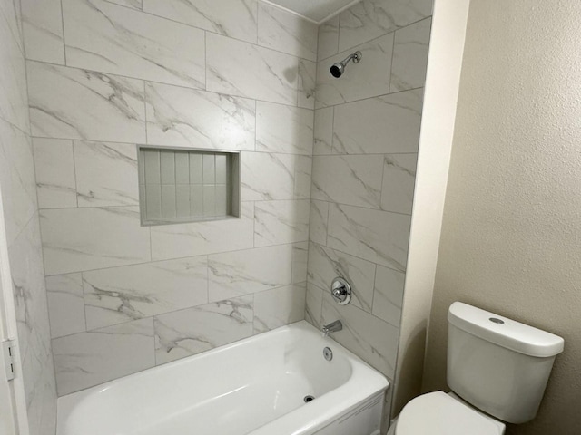 bathroom featuring toilet and tiled shower / bath