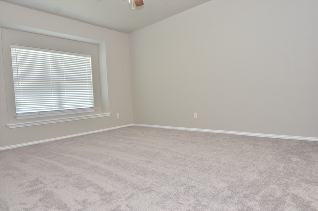 carpeted empty room featuring ceiling fan